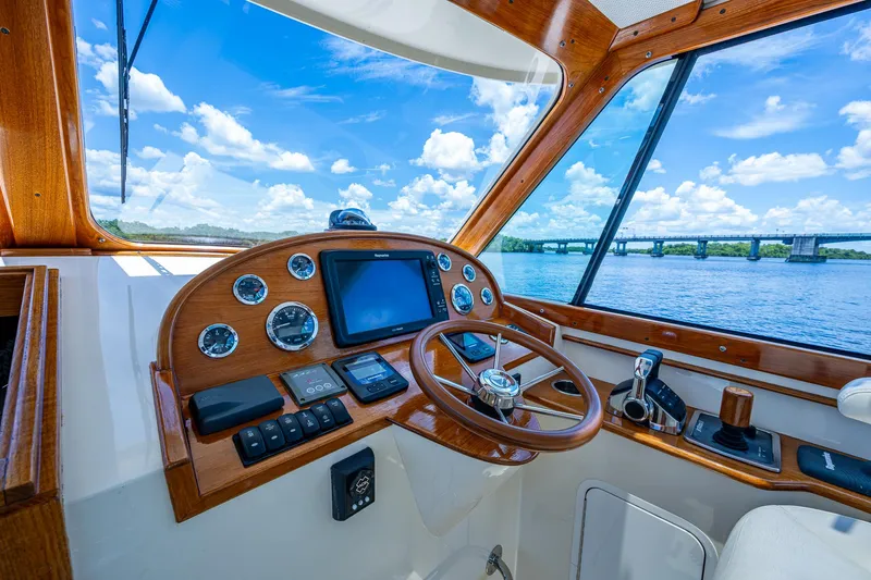 San Marco Yacht Photos Pics Helm of 2016 Hinckley Talaria 34 yacht with wooden dashboard and scenic water view.