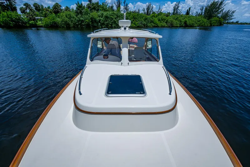 San Marco Yacht Photos Pics 2016 Hinckley Talaria 34 cruising on a serene lake with lush greenery.