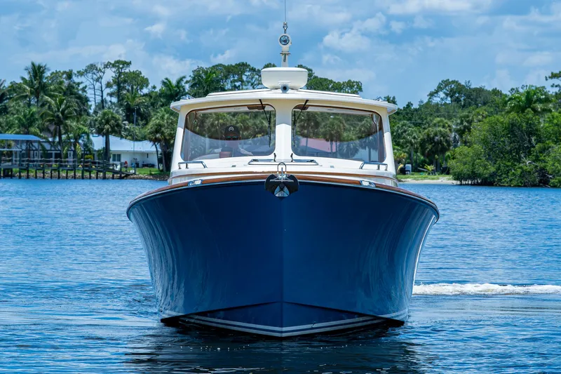 San Marco Yacht Photos Pics 2016 Hinckley Talaria 34 yacht on a serene waterway, surrounded by lush greenery.