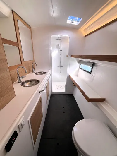 Iago Yacht Photos Pics Modern bathroom interior of 2021 Marsaudon Composites ORC 50 yacht, featuring dual sinks and shower.
