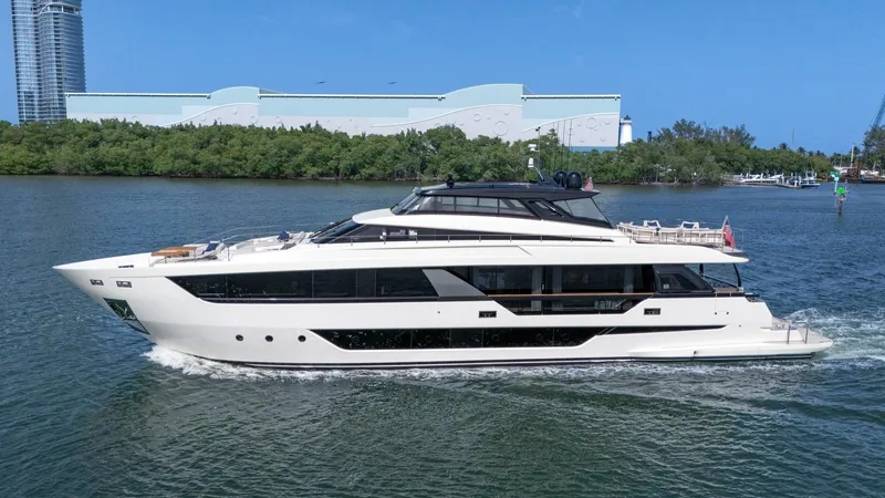 Aurora Yacht Photos Pics Luxury 2022 Ferretti Yachts 1000 cruising on a sunny day near a modern cityscape.