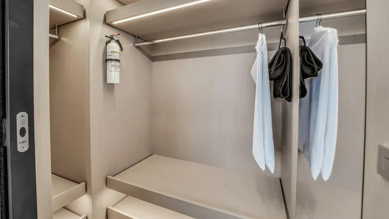 Aurora Yacht Photos Pics Spacious closet in 2022 Ferretti Yachts 1000 with hangers and fire extinguisher.