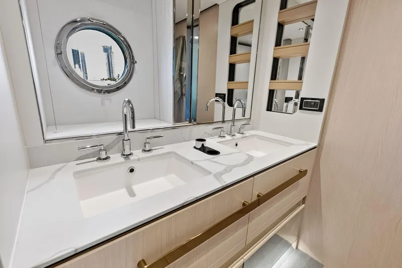  Yacht Photos Pics Luxurious bathroom interior of 2021 Azimut Fly 78 yacht with dual sinks and porthole window.