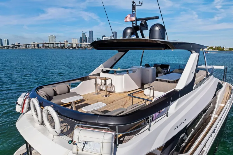  Yacht Photos Pics Luxurious 2021 Azimut Fly 78 yacht with spacious deck, city skyline in background.