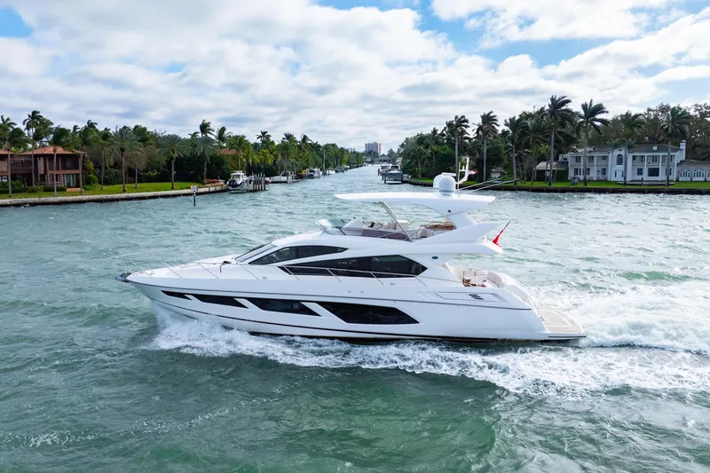  Yacht Photos Pics 2016 Sunseeker Manhattan 65 yacht cruising on a scenic waterway with palm trees.