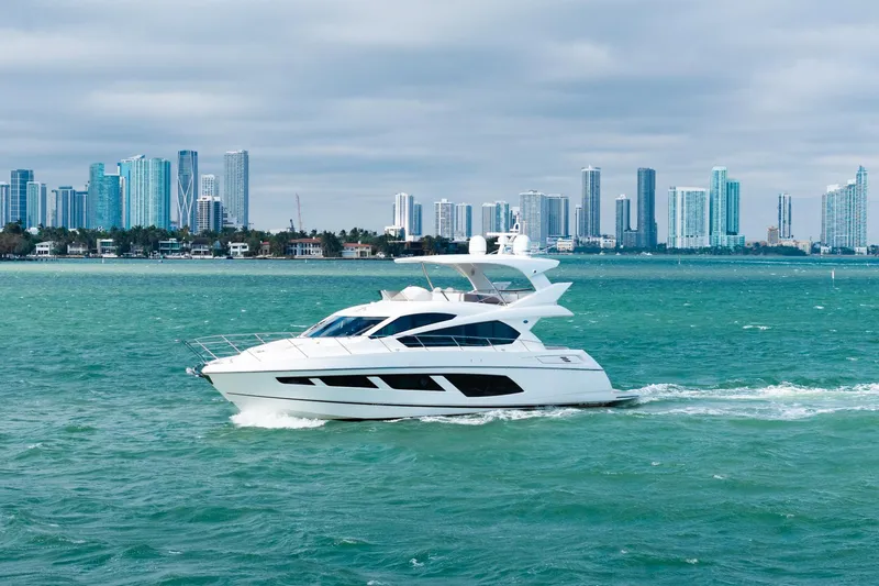  Yacht Photos Pics 2016 Sunseeker Manhattan 65 yacht cruising near a city skyline.