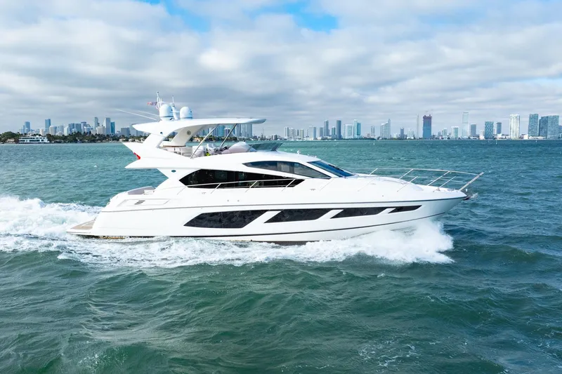  Yacht Photos Pics 2016 Sunseeker Manhattan 65 yacht cruising on open water with city skyline backdrop.