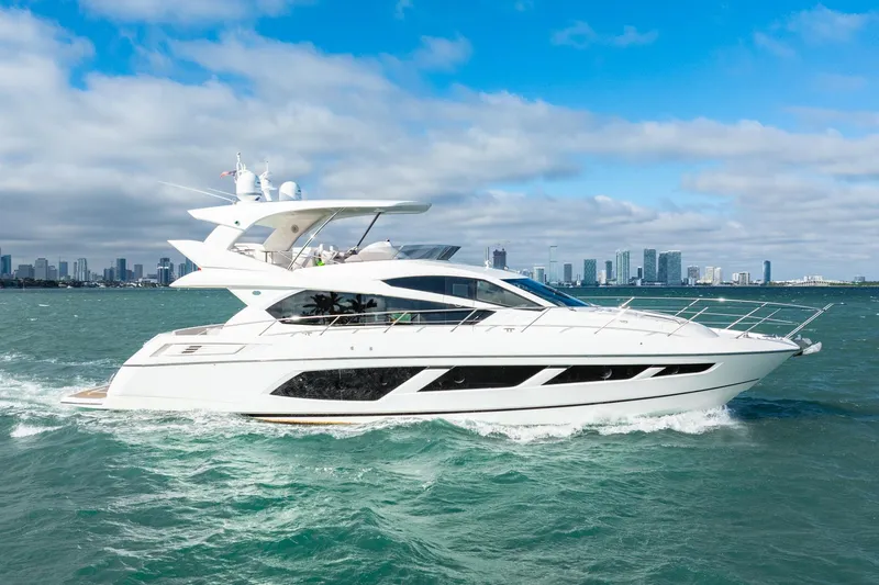  Yacht Photos Pics 2016 Sunseeker Manhattan 65 yacht cruising on open water with city skyline backdrop.