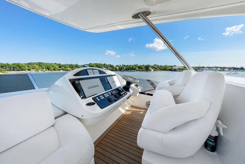  Yacht Photos Pics 2016 Sunseeker Manhattan 65 yacht helm with white seating and navigation controls, overlooking water.