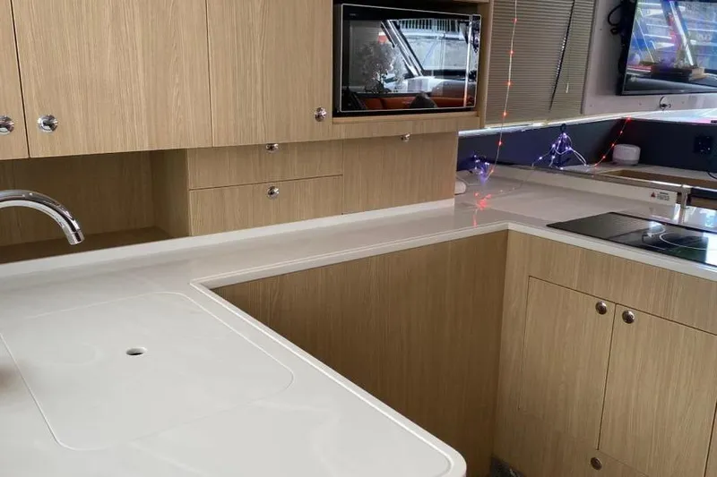  Yacht Photos Pics Modern kitchen interior of 2023 Aquila 42 yacht with sleek cabinetry and appliances.