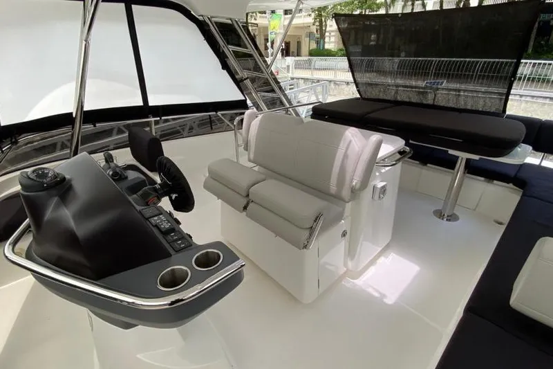  Yacht Photos Pics Interior of 2023 Aquila 42 yacht featuring helm, seating, and table in modern design.