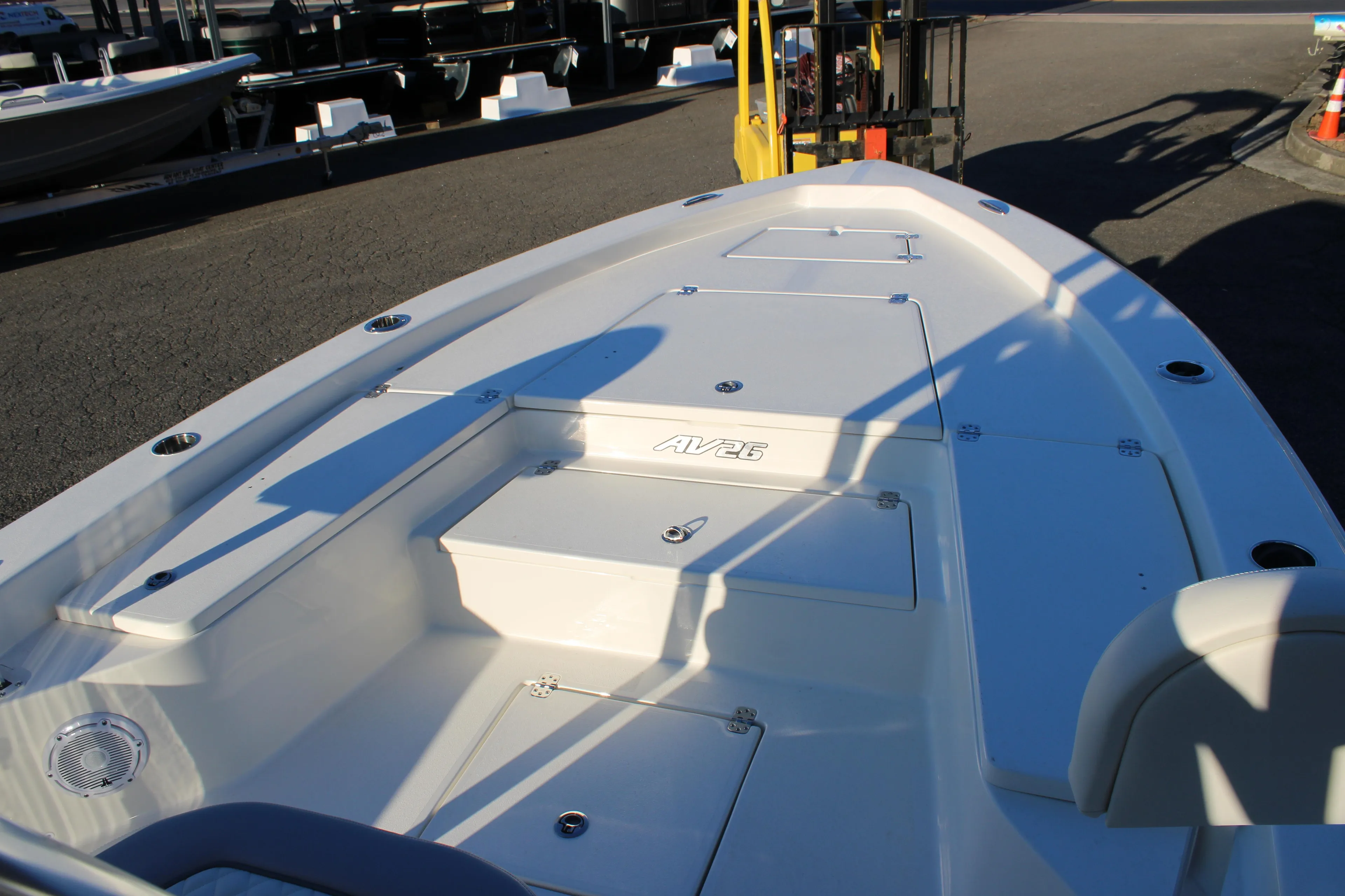 2025 Avenger AV26 boat deck with storage compartments and seating in a marina setting.