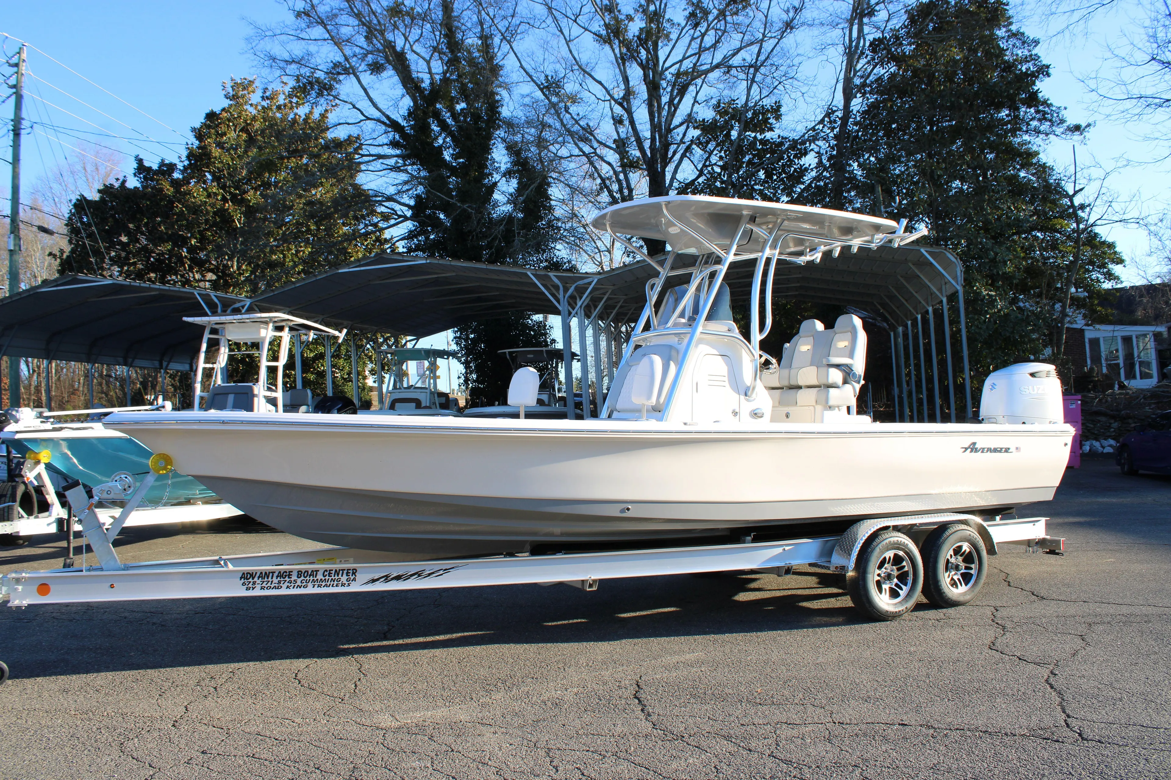 2025 Avenger AV26 boat on trailer, parked outdoors, surrounded by trees.