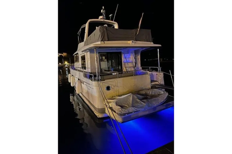 Odoo Id - 2.110 Yacht Photos Pics 2021 Beneteau Swift Trawler 50 docked at night with blue underwater lights.