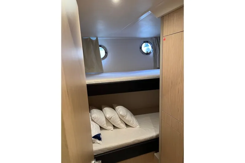 Odoo Id - 2.110 Yacht Photos Pics 2021 Beneteau Swift Trawler 50 cabin with bunk beds and porthole windows.