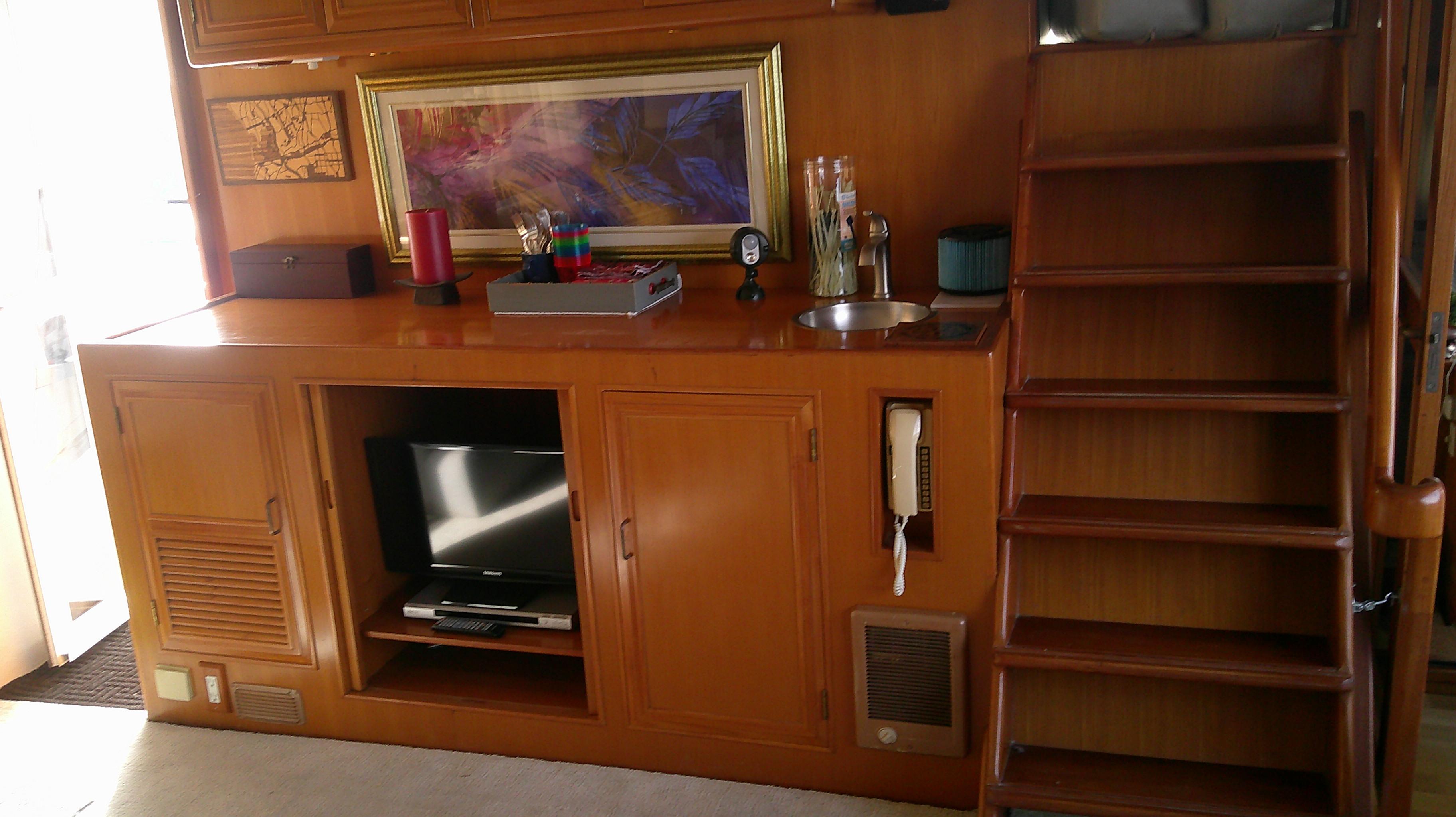 1996 Ocean Alexander 546 Yachtfisher interior with wooden cabinetry, TV, and staircase.