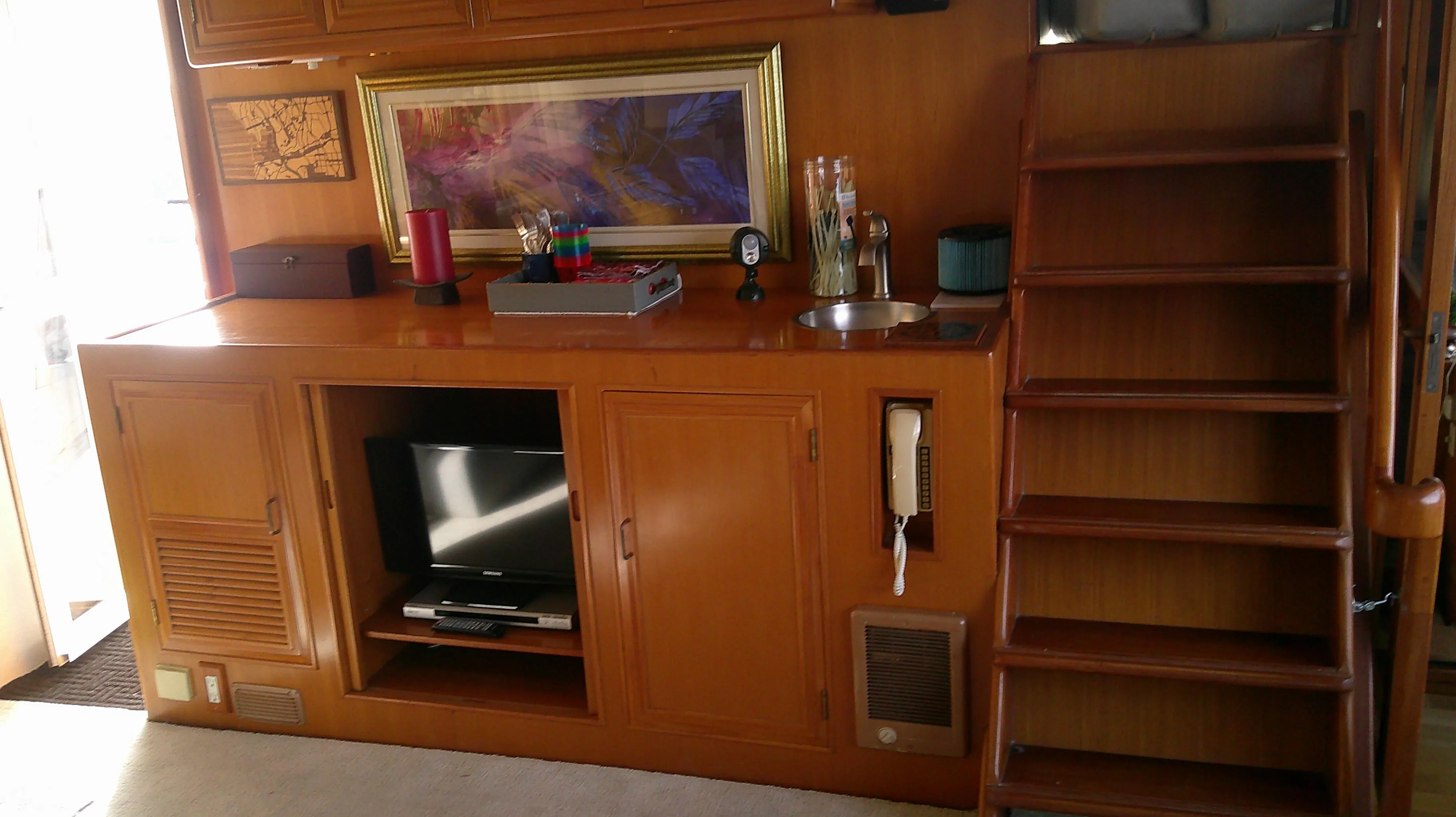 1996 Ocean Alexander 546 Yachtfisher interior with wooden cabinetry, TV, and staircase.