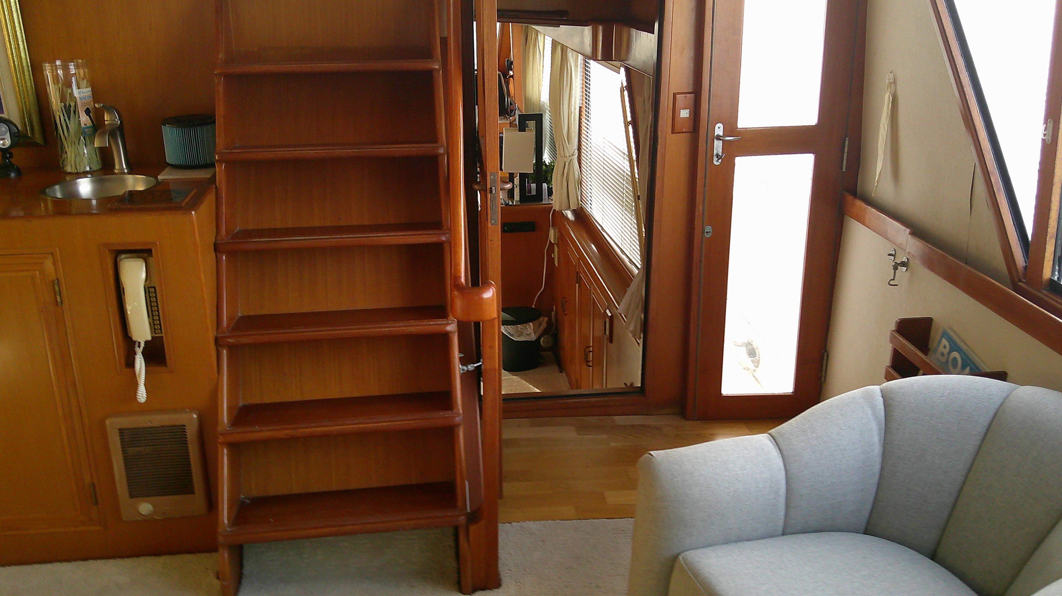 Interior of 1996 Ocean Alexander 546 Yachtfisher with wooden stairs and cozy seating.