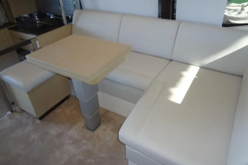 Dream Big Yacht Photos Pics Luxurious interior of 2023 Prestige 420S yacht with beige seating and dining table.