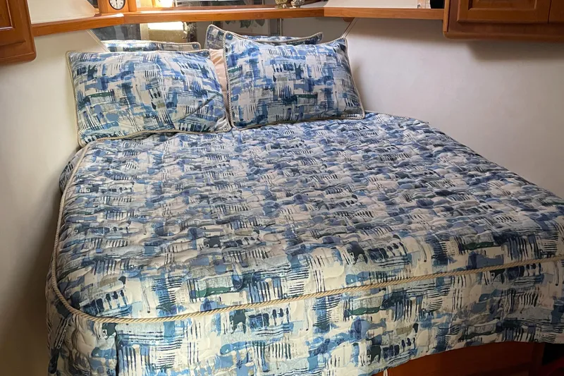 Tiramisu Yacht Photos Pics Cozy bedroom with blue-patterned bedding in 1996 Viking 47 Convertible yacht.