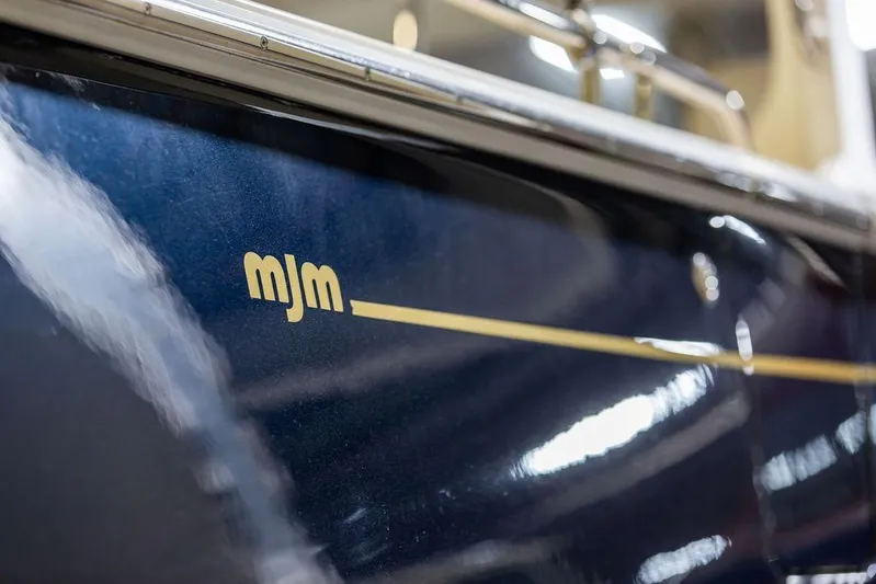 Mare Yacht Photos Pics Close-up of 2018 MJM 35z boat with logo on sleek blue hull.