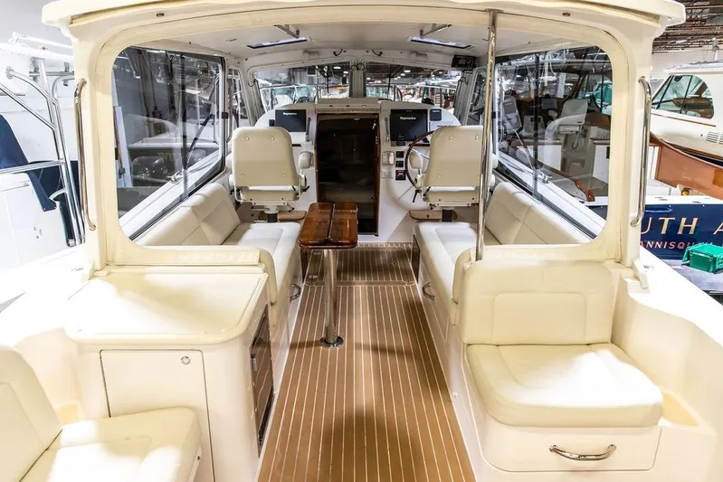 Mare Yacht Photos Pics 2018 MJM 35z boat interior with seating, wooden table, and helm station.