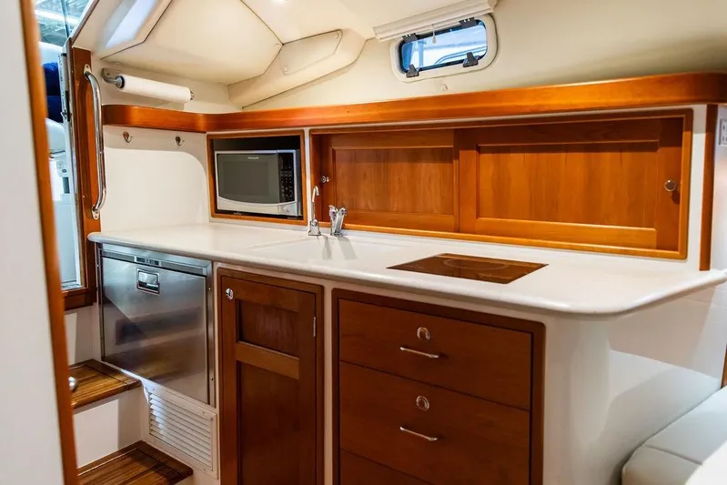 Mare Yacht Photos Pics Luxurious 2018 MJM 35z yacht kitchen with wood cabinetry, microwave, and stainless steel appliances.