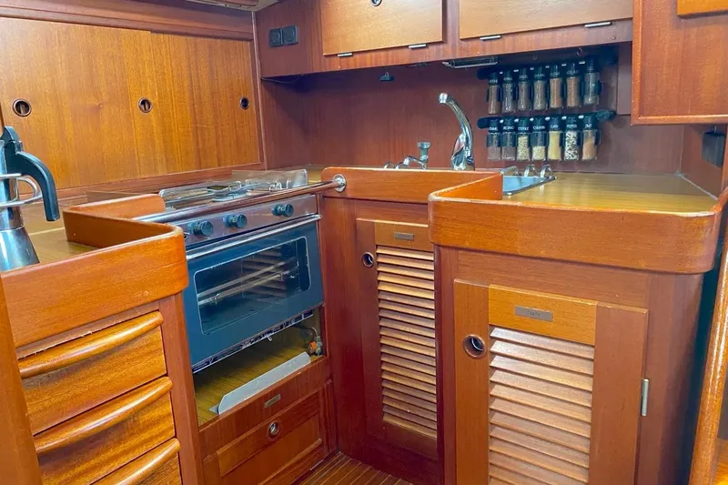 Challanger Yacht Photos Pics Wooden kitchen interior of 1992 Hallberg-Rassy 45 yacht with stove and spice rack.