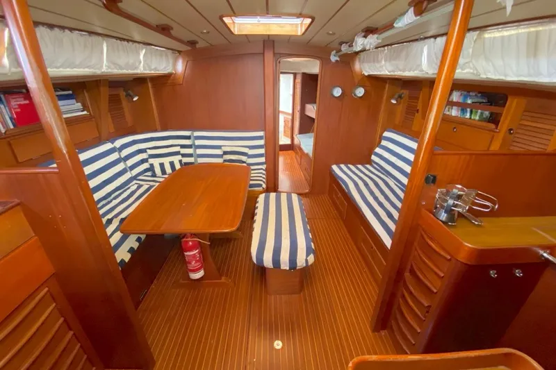 Challanger Yacht Photos Pics Interior of 1992 Hallberg-Rassy 45 yacht with striped seating and wooden finishes.