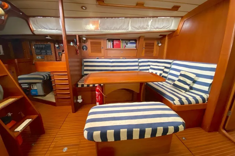 Challanger Yacht Photos Pics Interior of 1992 Hallberg-Rassy 45 yacht with striped seating and wooden finishes.