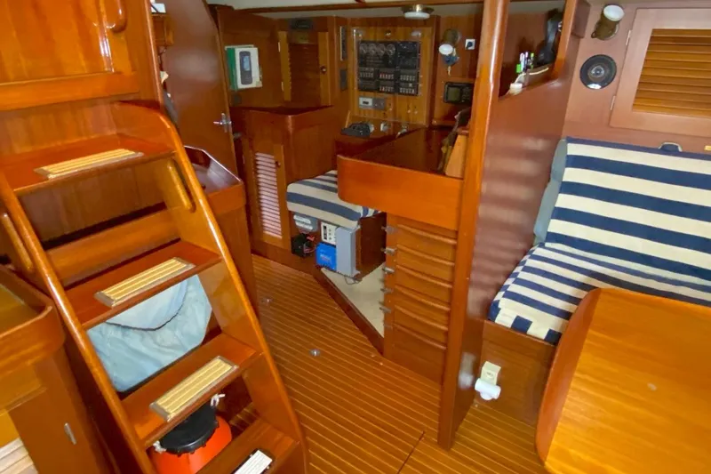 Challanger Yacht Photos Pics Interior of 1992 Hallberg-Rassy 45 yacht with wooden finish and striped seating.