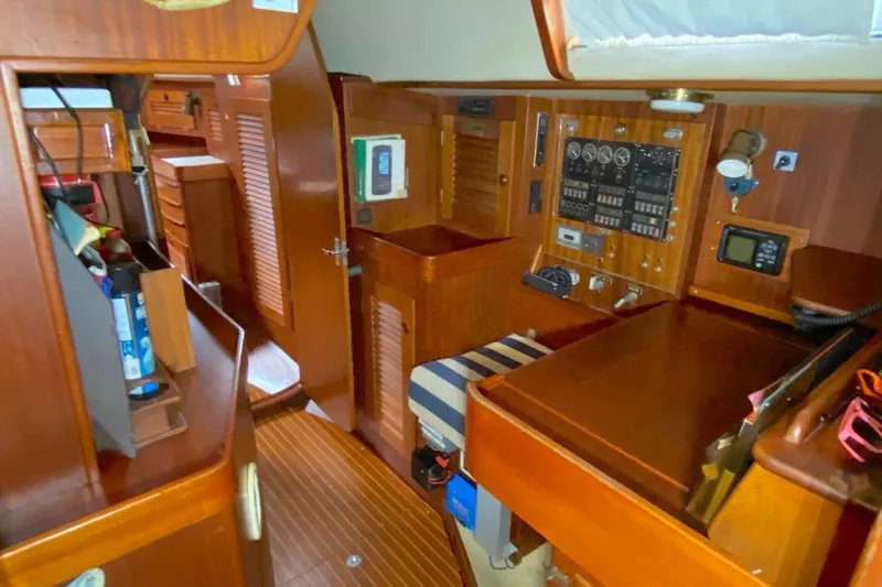 Challanger Yacht Photos Pics Interior of 1992 Hallberg-Rassy 45 yacht with wooden cabinetry and navigation panel.