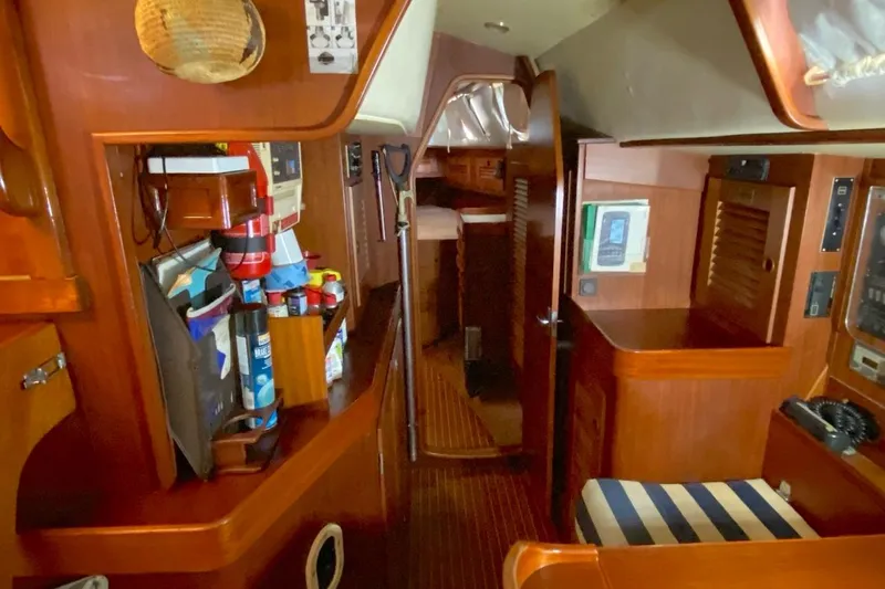 Challanger Yacht Photos Pics Interior of a 1992 Hallberg-Rassy 45 yacht, featuring wooden cabinetry and nautical equipment.