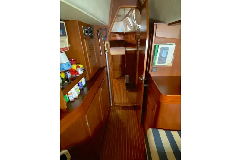 Challanger Yacht Photos Pics Interior of 1992 Hallberg-Rassy 45 yacht with wooden cabinetry and striped seating.