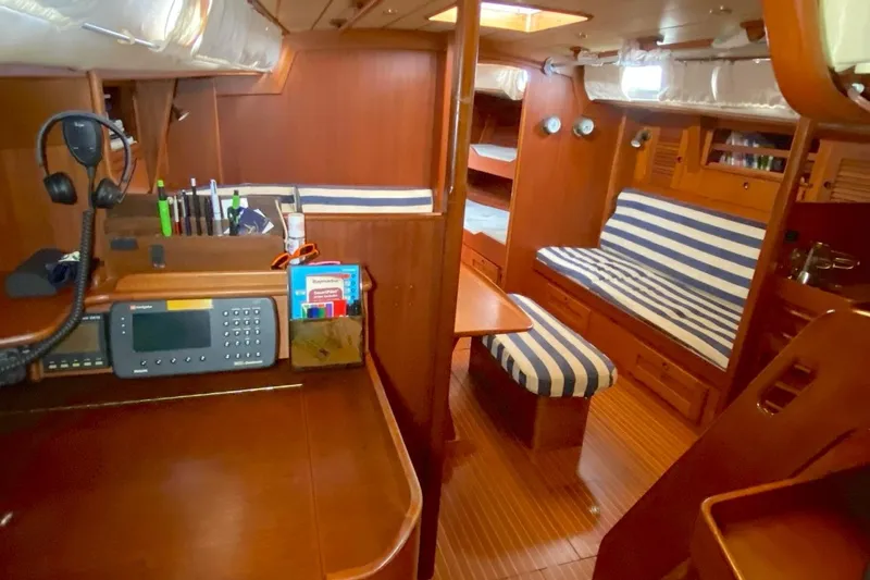 Challanger Yacht Photos Pics Interior of 1992 Hallberg-Rassy 45 yacht with striped seating and navigation equipment.
