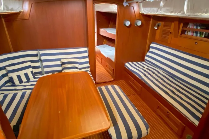 Challanger Yacht Photos Pics Interior of 1992 Hallberg-Rassy 45 yacht with striped seating and wooden finishes.