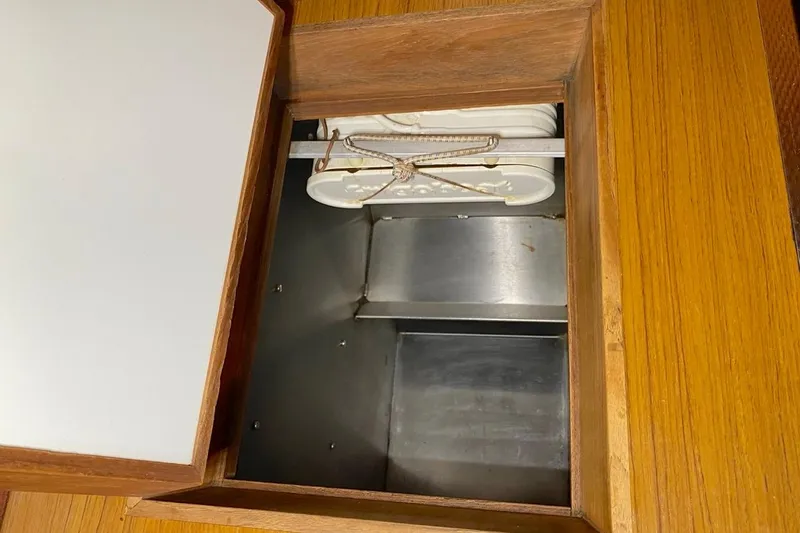 Challanger Yacht Photos Pics Open storage compartment on 1992 Hallberg-Rassy 45 yacht with wooden and metal interior.