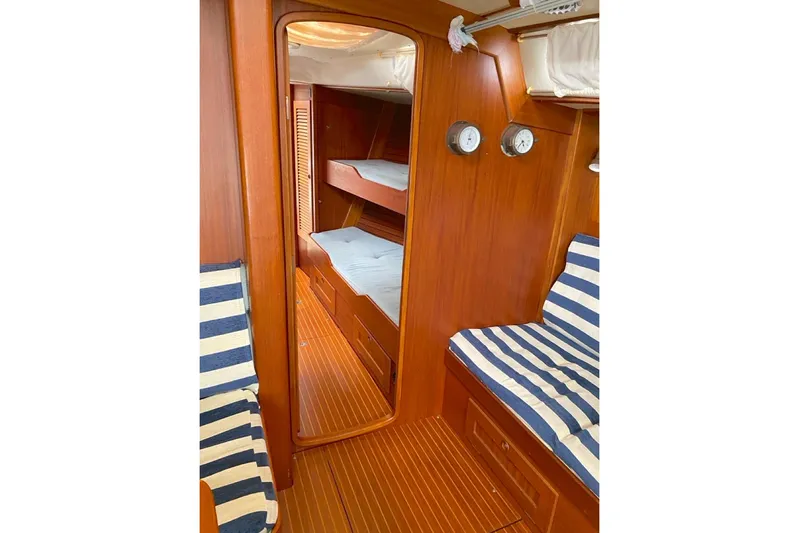 Challanger Yacht Photos Pics Interior of 1992 Hallberg-Rassy 45 yacht with wooden finish and striped seating.