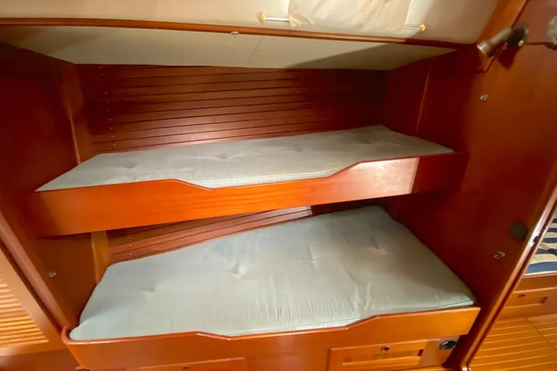 Challanger Yacht Photos Pics Interior of 1992 Hallberg-Rassy 45 yacht with wooden bunk beds and cushions.
