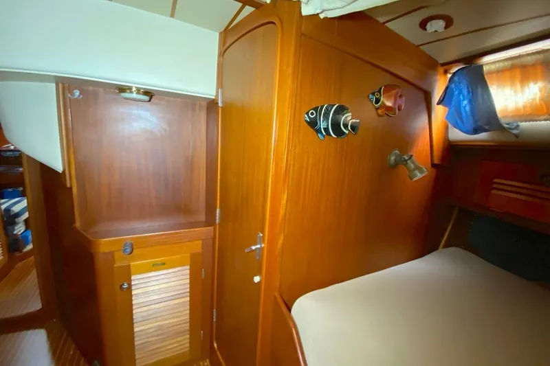 Challanger Yacht Photos Pics Interior of 1992 Hallberg-Rassy 45 yacht with wooden cabinetry and decorative fish.