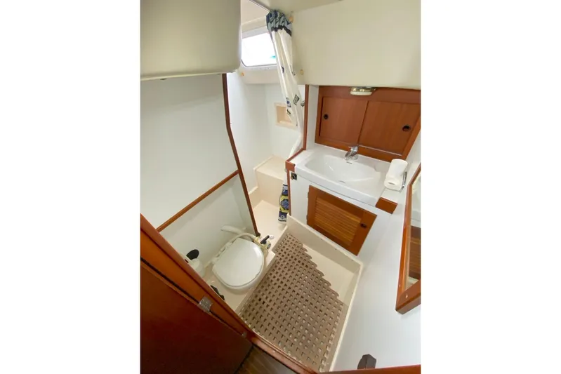 Challanger Yacht Photos Pics Bathroom interior of 1992 Hallberg-Rassy 45 yacht with sink, toilet, and wooden cabinetry.