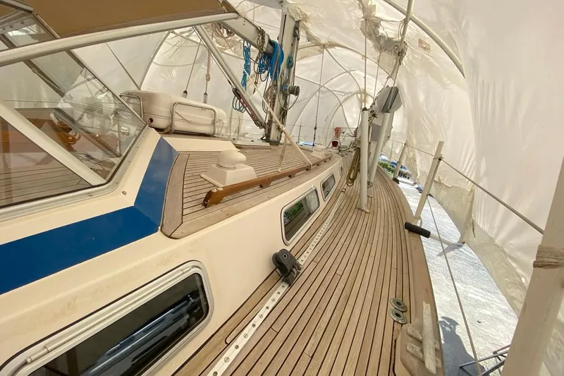 Challanger Yacht Photos Pics 1992 Hallberg-Rassy 45 sailboat deck under protective cover, showcasing teak wood finish.