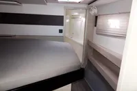 Modern interior of 2021 Leopard 50 yacht with bed and window blinds.