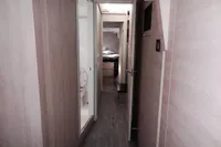 Hallway inside 2021 Leopard 50 yacht, featuring modern wood paneling and compact bathroom.