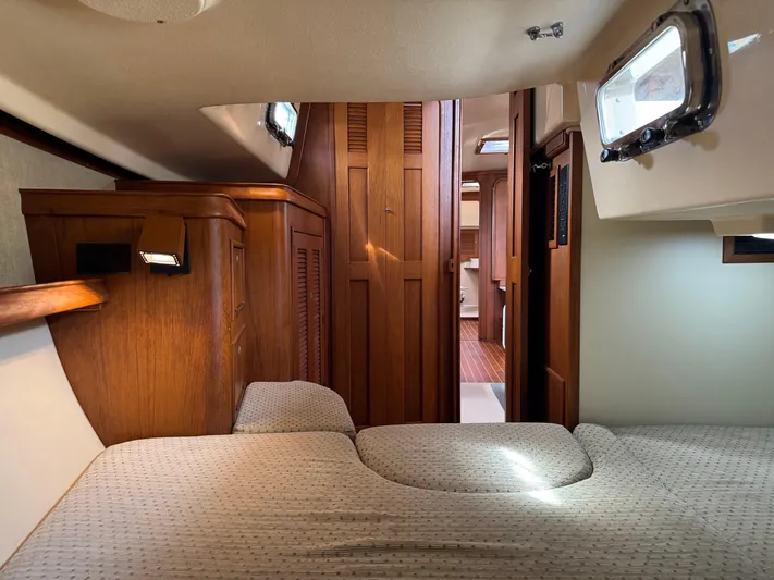 Otter II Yacht Photos Pics Interior cabin of 1999 Island Packet 45 sailboat with wooden finishes and cozy bedding.