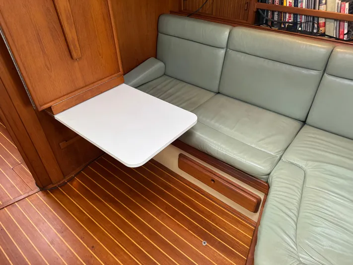 Otter II Yacht Photos Pics 1999 Island Packet 45 interior with green leather seating and foldable table.