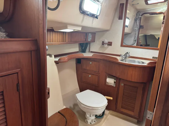 Otter II Yacht Photos Pics 1999 Island Packet 45 yacht bathroom with wooden cabinetry and compact design.