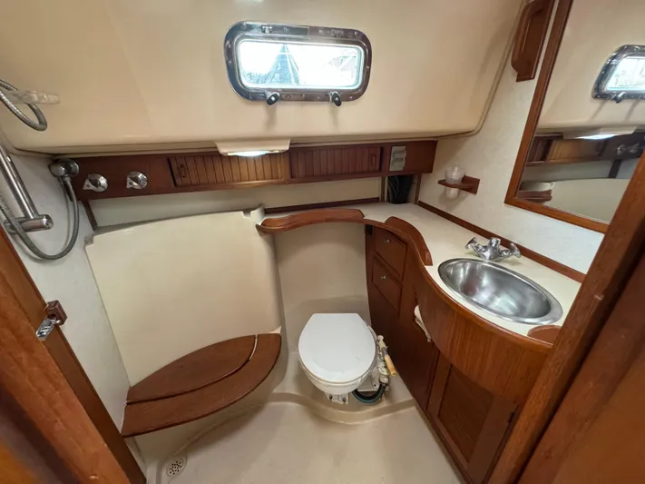 Otter II Yacht Photos Pics 1999 Island Packet 45 yacht bathroom with wooden accents, sink, and toilet.