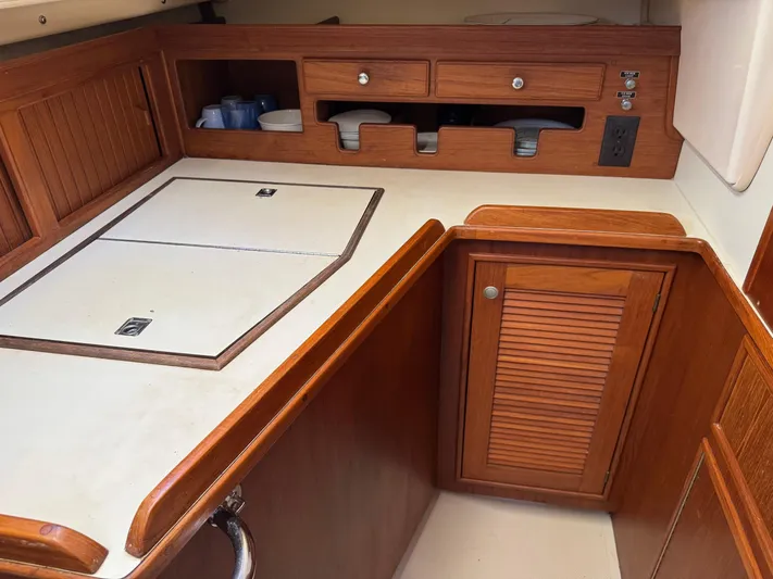 Otter II Yacht Photos Pics 1999 Island Packet 45 yacht kitchen with wooden cabinetry and white countertops.