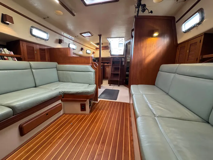 Otter II Yacht Photos Pics Interior of 1999 Island Packet 45 sailboat with wood flooring and cushioned seating.